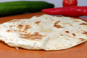 Homemade whole-wheat flour tortillas on a wooden table