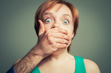 male hand shutting up woman