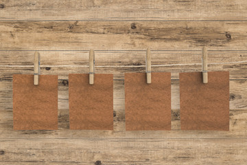 brown blank paper hanging on wooden background