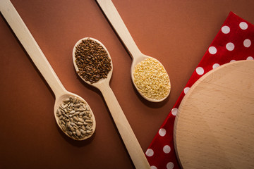 Sesame, sunflower seeds and linseed on a wooden spoon on the table
