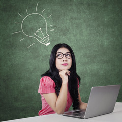 Smart girl with laptop having an idea