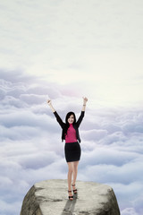 Successful worker standing on the mountain peak