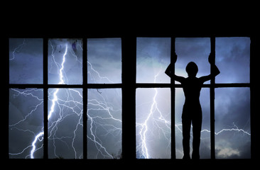 Fototapeta premium Silhouette of man watching lightning, thunder, rain and storm th