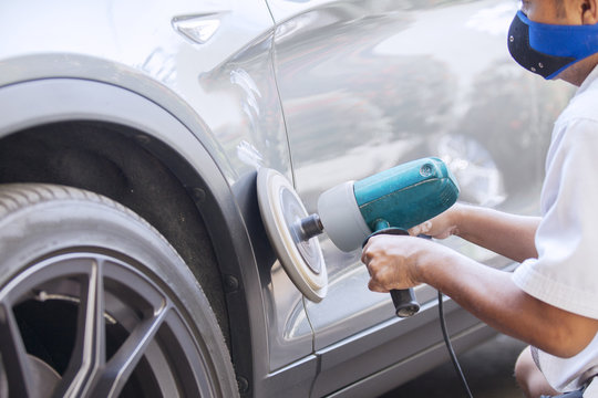 Worker Polishing A Car Body