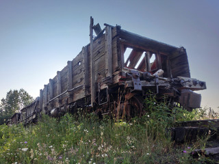 Fototapeta na wymiar Abandoned vintage weathered wooden mining cart outdoors - landscape color photo