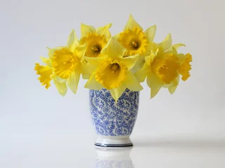 Foto op Canvas Bouquet of yellow daffodils flowers in a blue vase. Floral home decoration with bouquet of yellow narcissus flowers in a vase. © ivoraobrazy