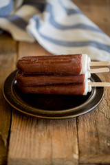 popsicle with grated chocolate on a wooden background