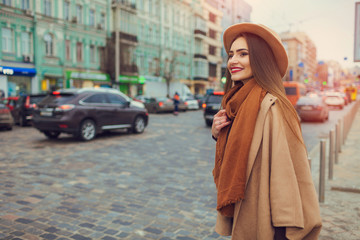 Naklejka premium Happy young pretty woman with hat walking down the street. Vacation Europe