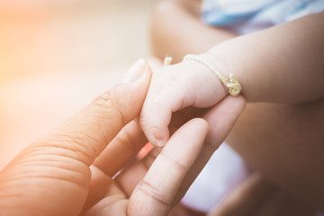Close-up of mother and baby's hands with soft focus