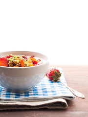 Smoothie bowl with strawberries, dried fruit, pistachio nuts and chia seeds, vertical shot, copy space