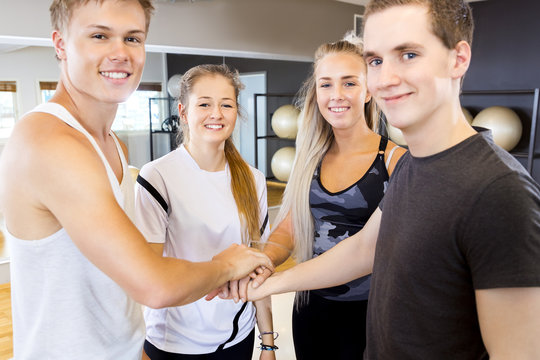 Close-up of cheerful fitness workout team holding hands