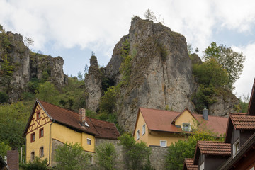 Fototapeta na wymiar Häuser unter Felsen in Pottenstein, Oberfranken, Deutschland