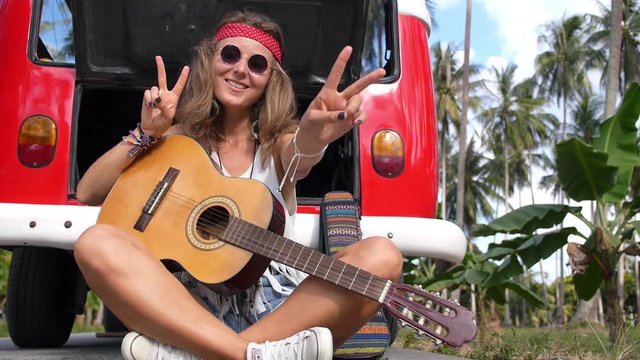 Young Hipster Hippie Woman Sitting on Road with Guitar