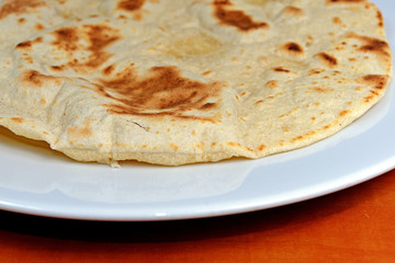 Homemade whole-wheat flour tortillas on a white plate