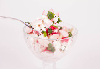 Cottage cheese with radish and chives in a cup eaten with a fork