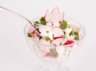 Cottage cheese with radish and chives in a cup eaten with a fork