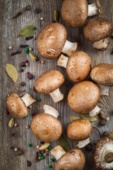 Mushrooms champignons and spices on wooden table. Top view.