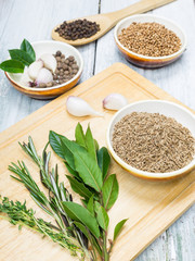 Cumin, rosemary and other spices on wooden background