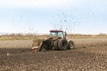 Tractor with double wheeled ditcher digging drainage canal