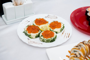 Red caviar with bread isolated. Appetizer of caviar with feta and dill, decorated with lemon.