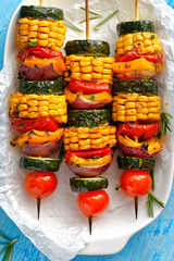 Grilled vegetarian skewers with zucchini, onion, bell pepper, corn and cherry tomatoes in a herb marinade