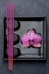 Spa with orchid and zen stones on black background