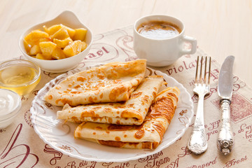 Breakfast. Pancakes, a cup of black coffee, honey and apples flambé