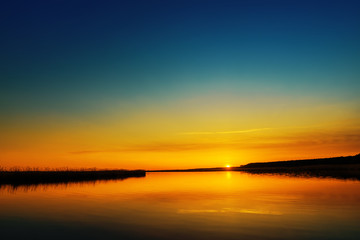 Fototapeta na wymiar orange sunset over river