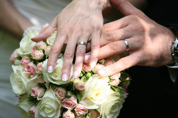Obraz na płótnie Canvas Wedding couple hands on rose bouquet