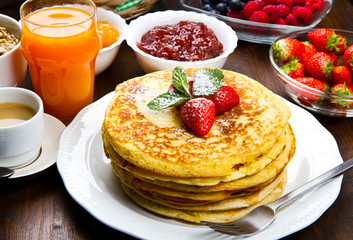 stack of freshly prepared traditional pancakes with strawberries