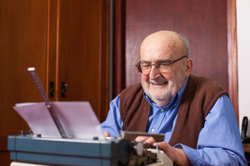 old man typing on a typewriter