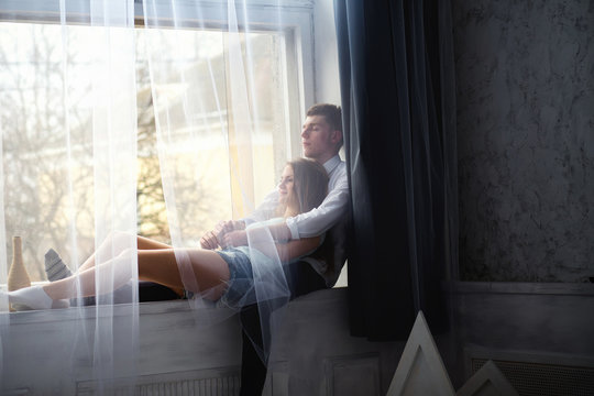 Young couple enjoying themselves on the windowsill - Powered by Adobe