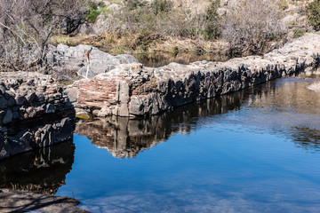 Fototapeta na wymiar Old Mission Dam wall and lake at Mission Trails Regional Park in San Diego, California.