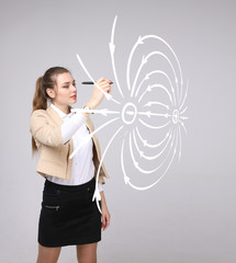 Young woman, physics teacher draws a diagram of the electric field