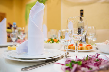 Restaurant table with glasses, napkins and cutlery