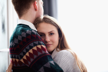 Happy woman dressed in  pullover put her head on shoulder of man