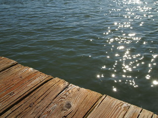 glistening water below weathered wooden dock