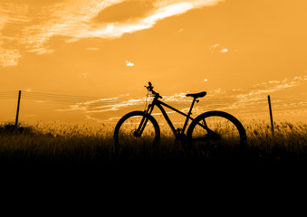 Silhouette Mountain biking, down hill at sunset