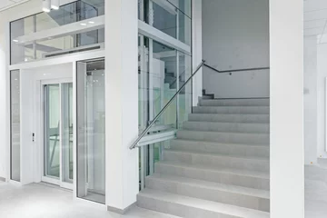 Cercles muraux Escaliers Vue de face de l& 39 ascenseur en verre dans un immeuble moderne.