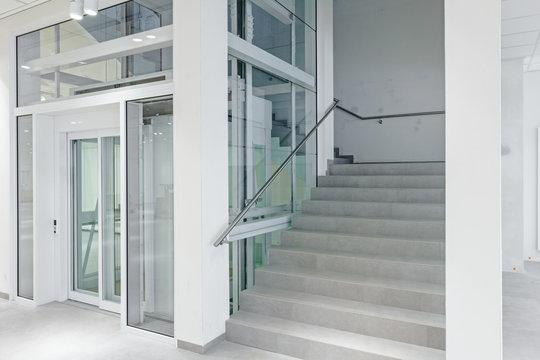 Front view of glass elevator in modern building.