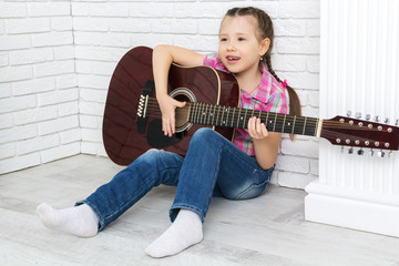 little girl playing the guitar and singing