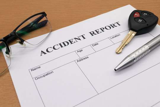 Accident report form with pen with glasses and key