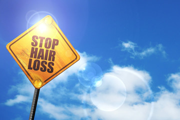Yellow road sign with a blue sky and white clouds: stop hair los