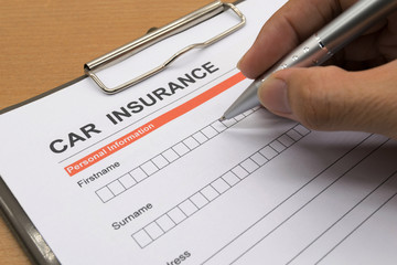 man signing a car insurance policy