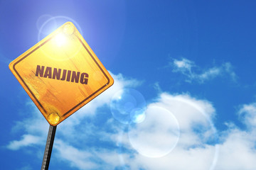 Yellow road sign with a blue sky and white clouds: nanjing