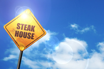 Yellow road sign with a blue sky and white clouds: Delicious ste