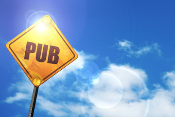 Yellow road sign with a blue sky and white clouds: pub sign back