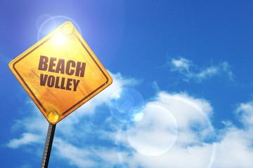 Yellow road sign with a blue sky and white clouds: beach volley 