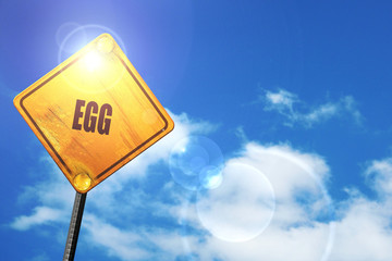Yellow road sign with a blue sky and white clouds: Delicious egg