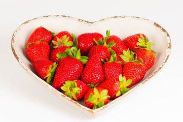 saftige Erdbeeren in herzförmiger Schale